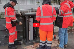 Techniciens intervenant sur une armoire électrique extérieure en polyester en environnement urbain